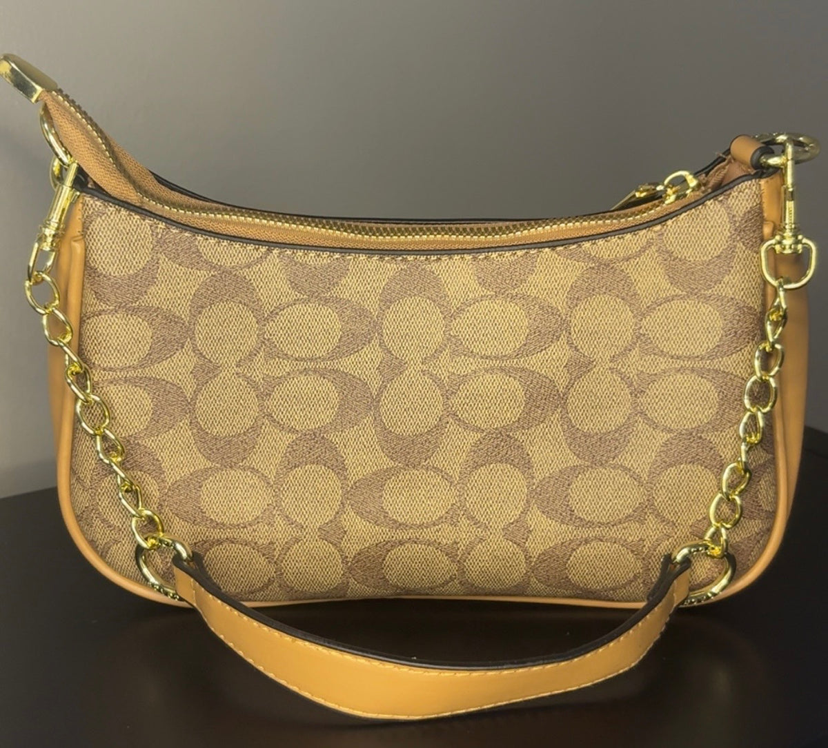 Coach crossbody bag with signature brown canvas.